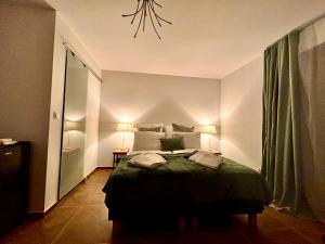 a bedroom with a large bed with a green blanket at Gryfon Dom in Jastarnia