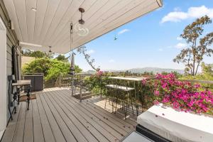 an outdoor deck with tables and chairs and pink flowers at Hilltop Escape-urban Oasis In Silverlakeecho Park in Los Angeles