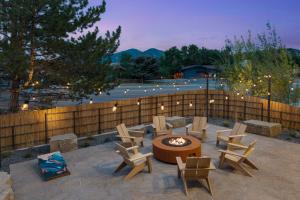 a patio with a fire pit and chairs and a fence at Wandering Buffalo in Bozeman