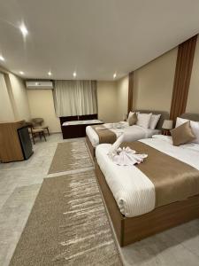 ein Hotelzimmer mit drei Betten und einem Klavier in der Unterkunft pyramids palace view iNN in Kairo