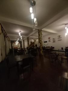 una habitación vacía con mesas, sillas y luces en Waves Rock ella, en Ella