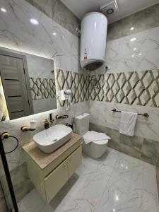 ein Badezimmer mit Waschbecken, Toilette und Spiegel in der Unterkunft pyramids palace view iNN in Kairo