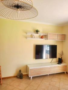 a living room with a flat screen tv on a wall at Porto Santo Rentals in Porto Santo +9 photos