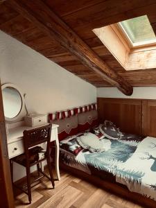 a bedroom with a bed and a desk and a mirror at Chalet Lumière Alpine in La Salle