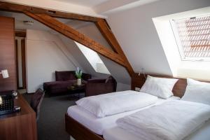 a bedroom with a bed and a living room at Hotel Zum Bären in Münnerstadt