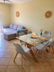 a living room with a glass table and chairs at Porto Santo Rentals in Porto Santo