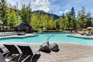 Una gran piscina con sillas y una mesa. en Tavern 16, en Olympic Valley