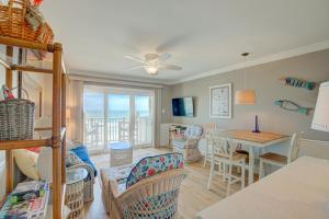 a living room with a table and chairs and a dining room at Topsail Dunes 1107 in North Topsail Beach