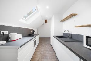 a white kitchen with a sink and a stove at Le Duplex Moutarde, prox centre et Gare, 50m2, climatisation in Chalon-sur-Saône