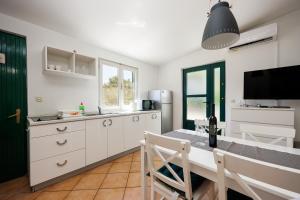 a kitchen with a table and chairs and a television at Karantanovi Dvori in Murter