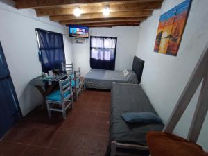 a small room with a bed and a table at Cabaña La tranquilidad in Santa Teresita