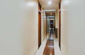 a hallway with white walls and wooden doors at Hotel O Span Executive in Pune +51 photos