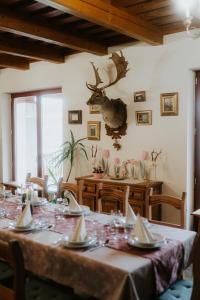 a dining room with a table with a deer head on the wall at Baglyas Birtok Rendezvény-és Vendégház in Nógrádmegyer