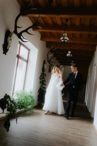 a bride and groom walking together in a hallway at Baglyas Birtok Rendezvény-és Vendégház in Nógrádmegyer