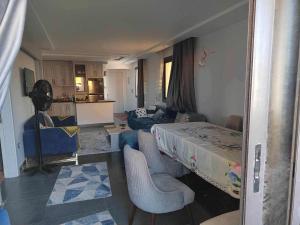 a living room with a bed and a couch and a kitchen at شقة بقرية هلنان بورفؤاد in Chantier Island