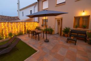 eine Terrasse mit Sonnenschirm, Tisch und Stühlen in der Unterkunft Aura Jacobea in Hornillos del Camino