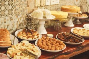 a table filled with different types of bread and pastries at Pousada Coqueiro do Caitá in Morro de São Paulo