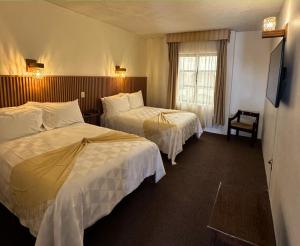 a hotel room with two beds and a window at Hotel Casa Santa María in Amealco