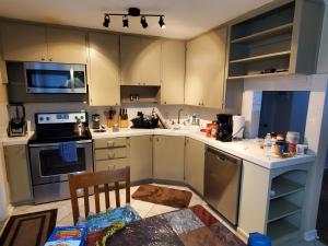 a kitchen with white cabinets and a table in it at Hist Two Bedroom Home in Avondale Riverside Jacksonville in Jacksonville