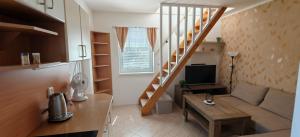a small living room with a couch and a staircase at Apartmán v Královském Údolí s předzahrádkou in Králŭv Dvŭr