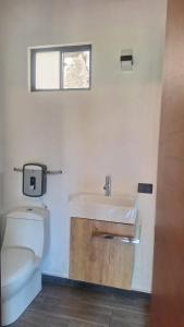 a bathroom with a white toilet and a sink at Román Cabañas del Mirador Cabaña 1 in Pahuatlán del Valle