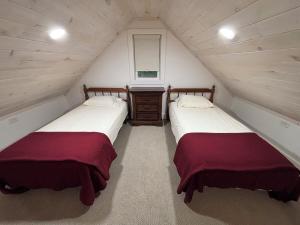 two beds in a small room with a window at Liberty Loft in Eagle Rock