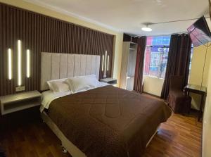 Un dormitorio con una cama grande y una ventana grande. en DON TITO Inn, en Puno