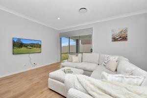 a white living room with a white couch at Hunter Valley Bercuti in North Rothbury