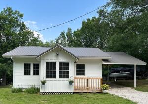 ein weißes kleines Haus mit einem grauen Dach in der Unterkunft Belle Cottage in Eagle Rock