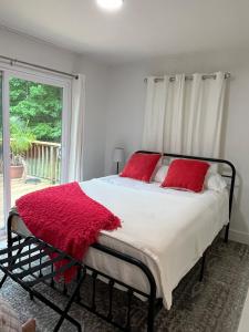 ein Schlafzimmer mit einem Bett mit roten Kissen und einem Fenster in der Unterkunft Belle Cottage in Eagle Rock