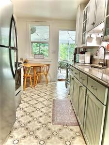 eine Küche mit einem Tisch und einem Kühlschrank in der Unterkunft Belle Cottage in Eagle Rock