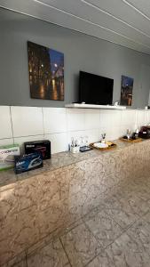een kamer met een aanrecht en een flatscreen-tv bij Ótima suíte privativa no Centro Histórico in Goiás