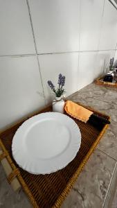 een wit bord op een rieten tafel bij Ótima suíte privativa no Centro Histórico in Goiás +11 foto's