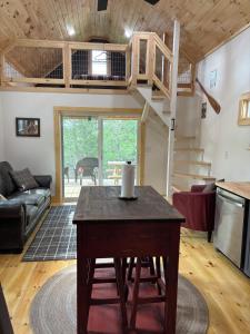 a living room with a table and a staircase at Camptown Cabin in Eagle Rock