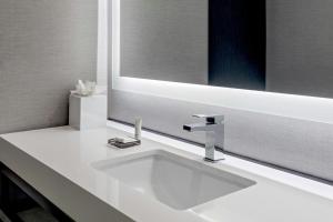 une salle de bain avec un lavabo blanc et un miroir dans l'établissement Denver Airport Marriott at Gateway Park, à Aurora 37 autres photos