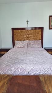 a bedroom with a large bed with a wooden headboard at Little House Downtown Morelia in Morelia