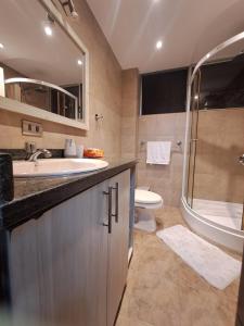 a bathroom with a sink and a toilet and a shower at Departamento en Tonsupa in Tonsupa