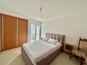 a bedroom with a large bed and a window at Da Luz Mar Azul in Mindelo