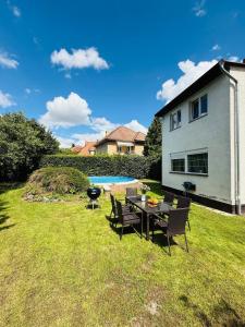 a backyard with a table and chairs and a pool at Family Villa Hanspaulka in Prague