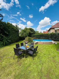 a table and chairs in a yard with a pool at Family Villa Hanspaulka in Prague