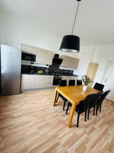 a kitchen with a wooden table and black chairs at Family Villa Hanspaulka in Prague