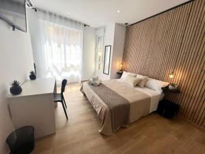 a bedroom with a bed and a desk and a window at Thor Hostal Boutique in Alicante