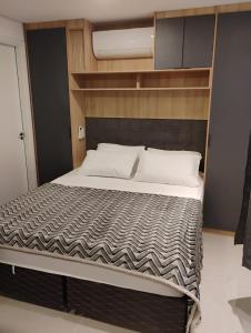a bedroom with a large bed with a wooden headboard at Studio 112 Luxuoso Cama Queen Ar Condicionado e Cozinha Completa in Mogi das Cruzes