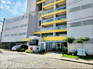 a building with a parking lot in front of it at Studio 112 Luxuoso Cama Queen Ar Condicionado e Cozinha Completa in Mogi das Cruzes