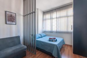 una piccola camera da letto con un letto e un divano di Maravilha centro Studio completo a Rio de Janeiro