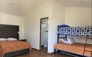a bedroom with two bunk beds and a bathroom at Tierra Linda in León