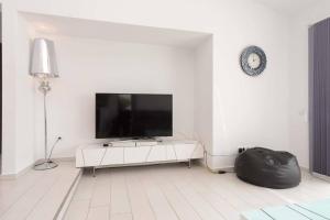 Una sala de estar blanca con un televisor de pantalla plana en una pared blanca. en Modern 3 Bedroom Villa Jaccuzi, en Playa Fañabe
