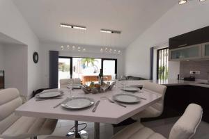 Un comedor y una cocina con una mesa y sillas blancas. en Modern 3 Bedroom Villa Jaccuzi, en Playa Fañabe 24 fotos más
