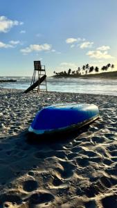 a blue kayak sitting on a beach with a chair at Canto das Praieiras - Porto de Sauípe, Rio & Mar in Porto de Sauipe +30 photos