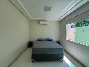 a bedroom with a bed in a room with a window at Beach House Atalaia in Aracaju +21 photos